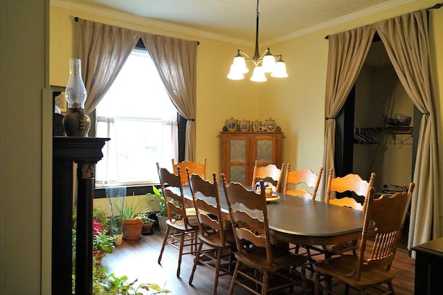 dining area with hardwood / wood-style floors, crown molding, and a notable chandelier