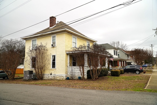 view of side of property with cooling unit and a porch