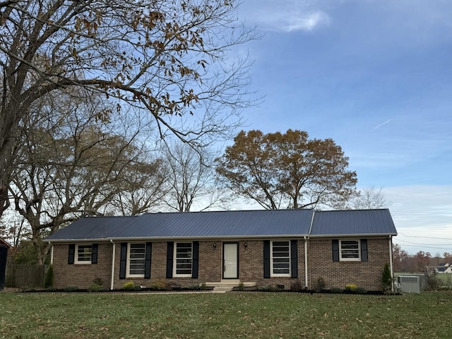 single story home with crawl space, metal roof, a front lawn, and brick siding