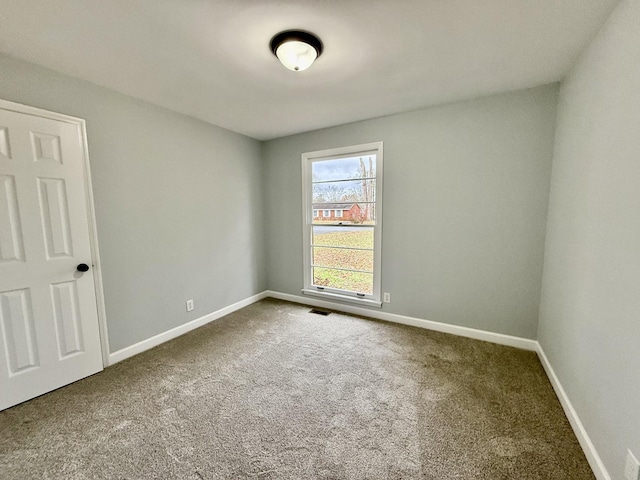 carpeted spare room with baseboards