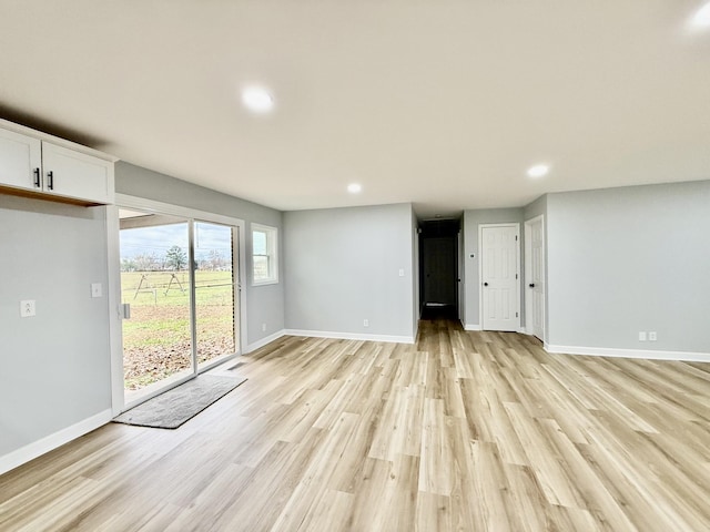 unfurnished living room featuring light wood finished floors, recessed lighting, and baseboards