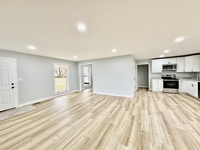 unfurnished living room with light wood-style floors, baseboards, and recessed lighting