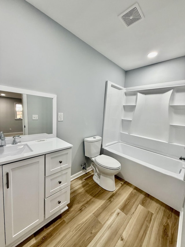 bathroom with shower / bathtub combination, visible vents, toilet, vanity, and wood finished floors