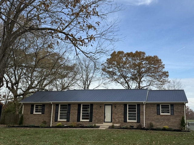 single story home featuring a front lawn, metal roof, and brick siding