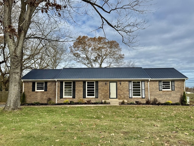 ranch-style house featuring metal roof, a front lawn, and brick siding