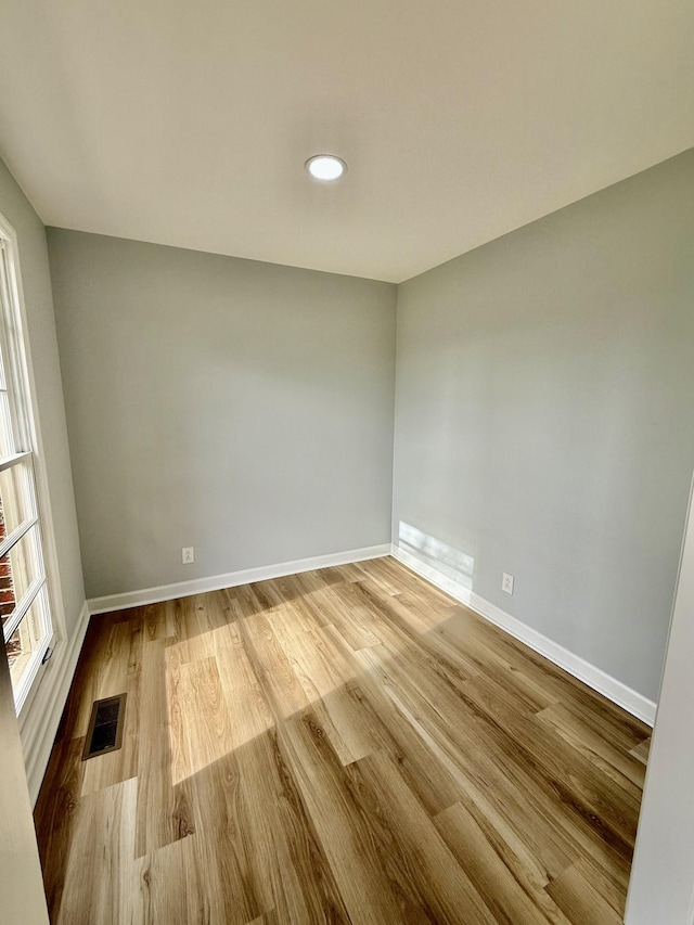 spare room featuring light wood-style floors, recessed lighting, visible vents, and baseboards