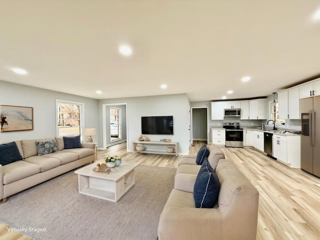 living area with light wood-type flooring and recessed lighting