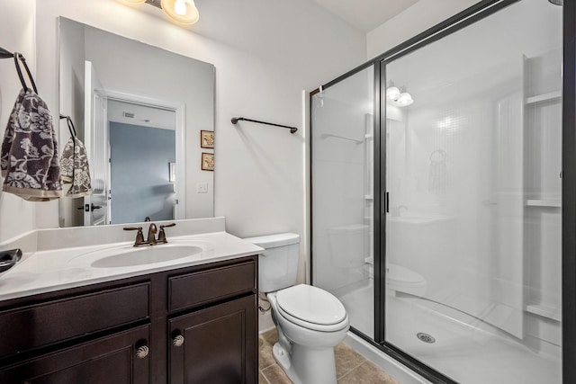 bathroom with tile patterned flooring, vanity, toilet, and walk in shower