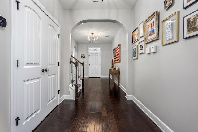 hall featuring dark hardwood / wood-style flooring and a chandelier