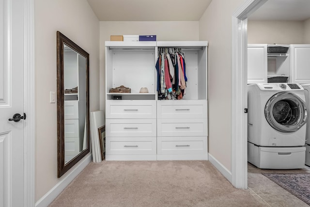 laundry area with cabinets, washer / dryer, and light colored carpet