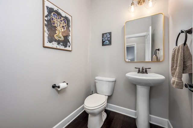 bathroom with sink, toilet, and hardwood / wood-style flooring