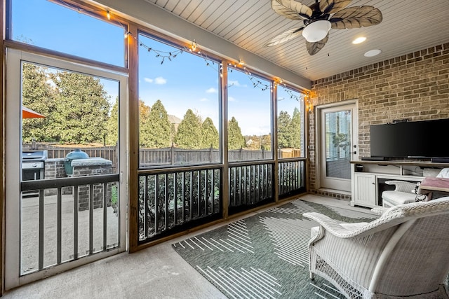 sunroom featuring ceiling fan and wood ceiling