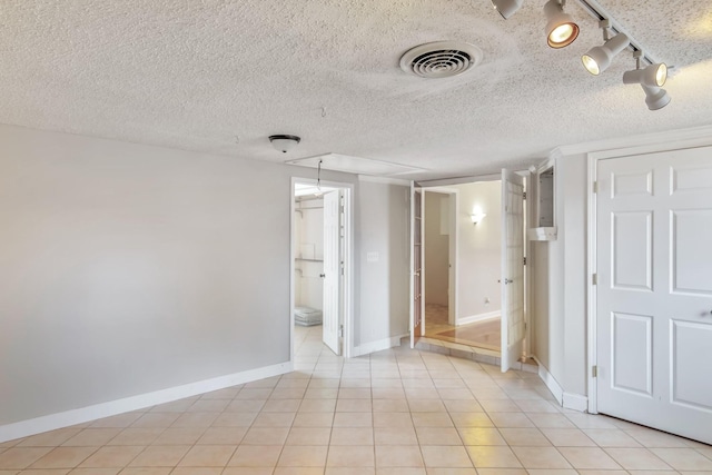 interior space featuring a textured ceiling and light tile patterned flooring