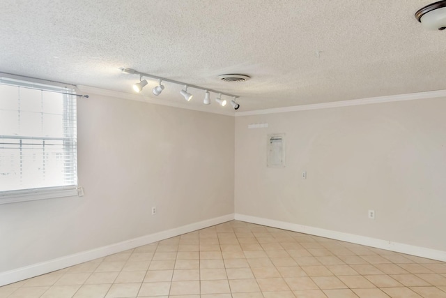 tiled empty room featuring crown molding and a textured ceiling