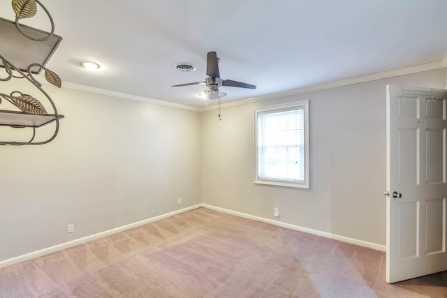 spare room featuring ceiling fan, light colored carpet, and ornamental molding