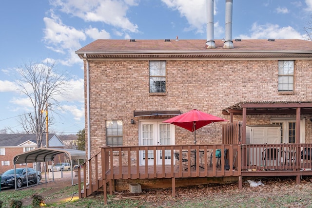 back of property with a deck and a carport