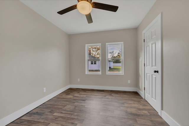 empty room with dark hardwood / wood-style floors and ceiling fan