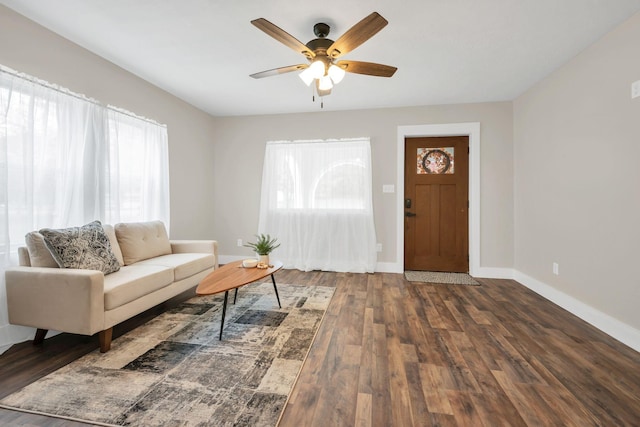 living room with dark hardwood / wood-style floors, ceiling fan, and a wealth of natural light