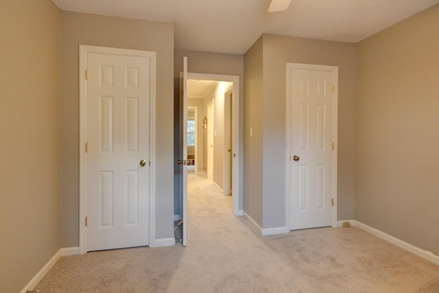 unfurnished bedroom featuring light carpet and ceiling fan