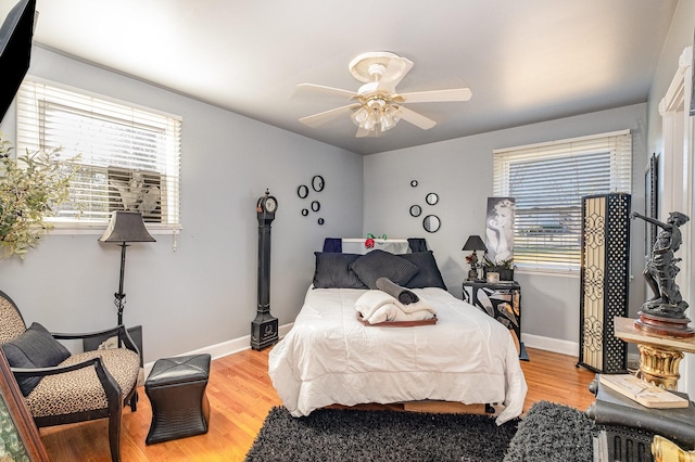 bedroom featuring multiple windows, ceiling fan, and light wood-type flooring