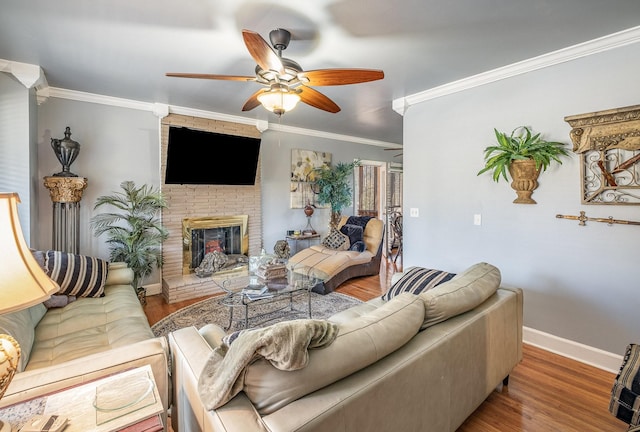 living room featuring hardwood / wood-style flooring, a fireplace, ornamental molding, and ceiling fan