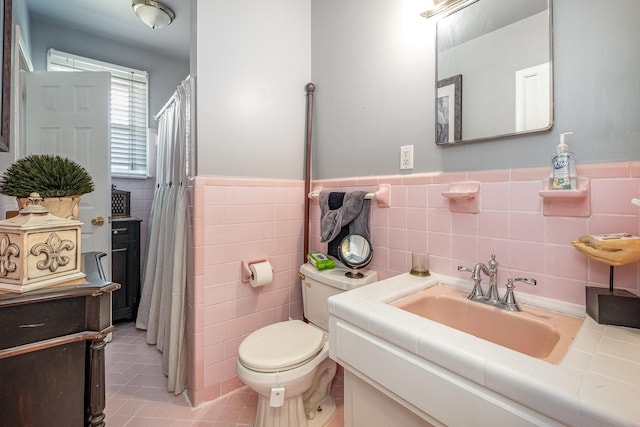 bathroom featuring vanity, tile patterned floors, tile walls, and toilet