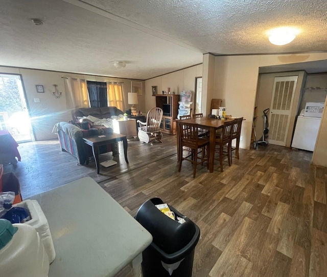 dining area with dark hardwood / wood-style floors, a textured ceiling, and washer / clothes dryer