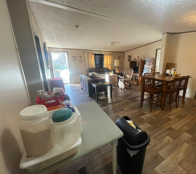 dining space featuring dark hardwood / wood-style flooring and a textured ceiling