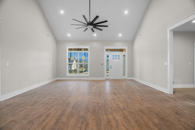 unfurnished living room featuring ceiling fan, high vaulted ceiling, recessed lighting, wood finished floors, and baseboards