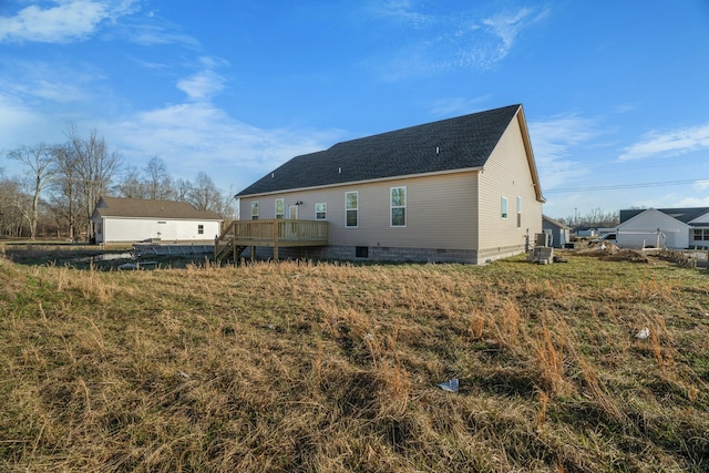 rear view of property featuring crawl space, a shingled roof, and a deck