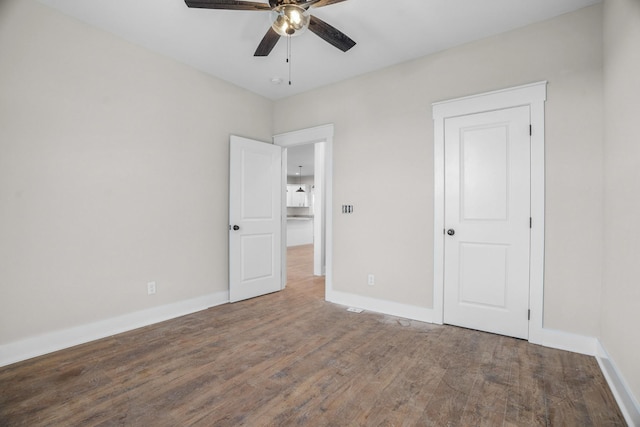 unfurnished bedroom featuring ceiling fan, baseboards, and wood finished floors