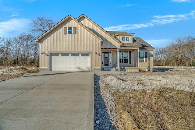 view of front of property with a garage, driveway, a shingled roof, and board and batten siding