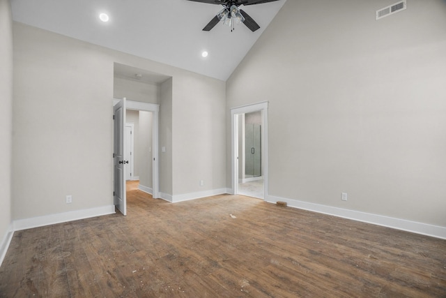 empty room with high vaulted ceiling, a ceiling fan, visible vents, baseboards, and dark wood-style floors