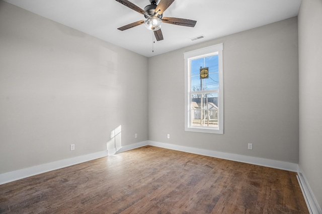 empty room with baseboards, visible vents, ceiling fan, and wood finished floors