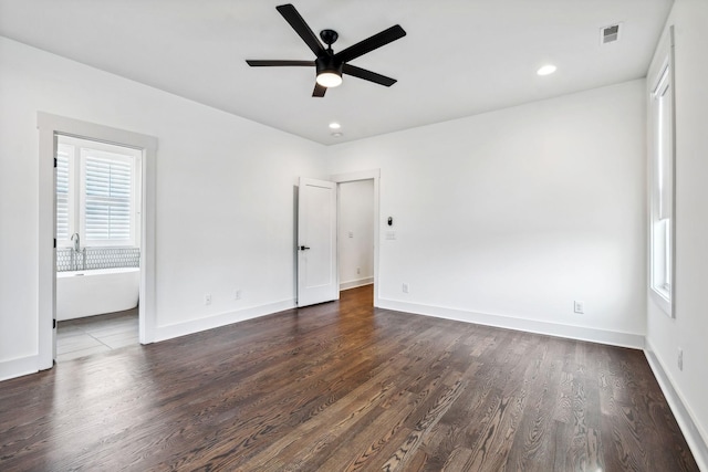 spare room featuring ceiling fan and dark wood-type flooring