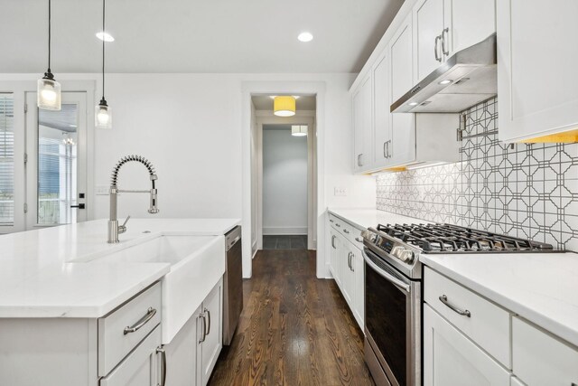 kitchen with white cabinetry, dark hardwood / wood-style flooring, decorative light fixtures, decorative backsplash, and appliances with stainless steel finishes