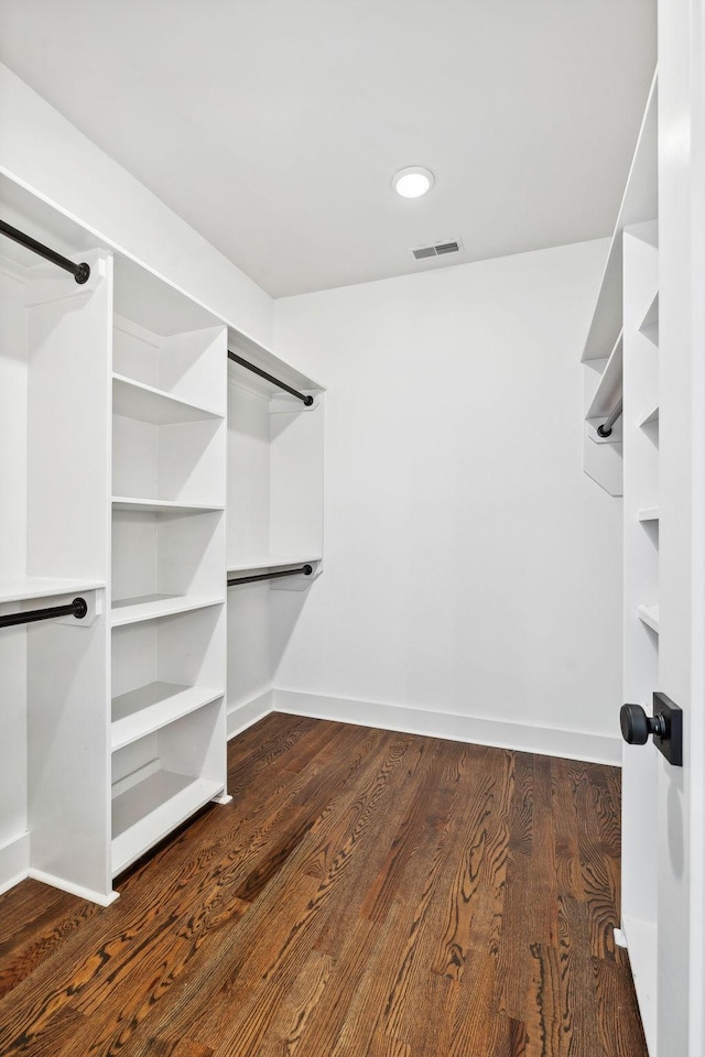 spacious closet featuring dark hardwood / wood-style flooring