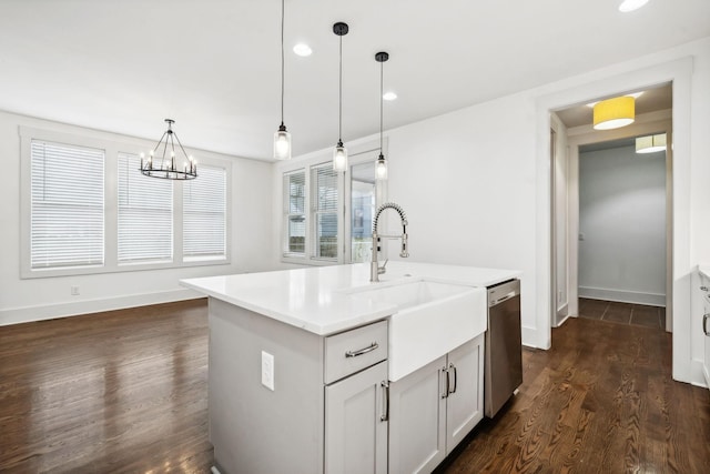 kitchen featuring dishwasher, dark hardwood / wood-style flooring, a notable chandelier, an island with sink, and pendant lighting