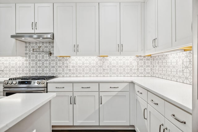 kitchen featuring stainless steel range, decorative backsplash, white cabinets, and exhaust hood