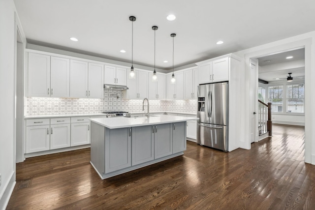 kitchen with ceiling fan, dark wood-type flooring, stainless steel appliances, decorative light fixtures, and white cabinets