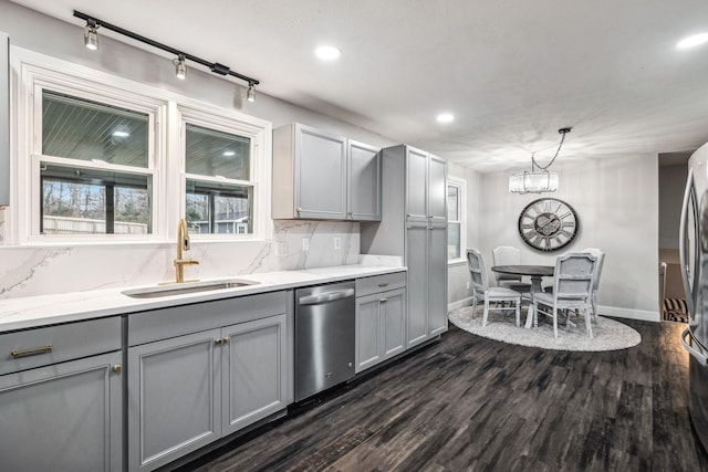 kitchen featuring pendant lighting, sink, dark hardwood / wood-style floors, gray cabinets, and stainless steel appliances