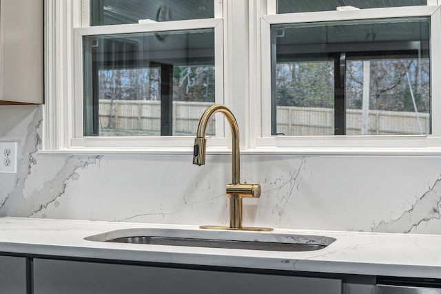 room details with light stone countertops and sink