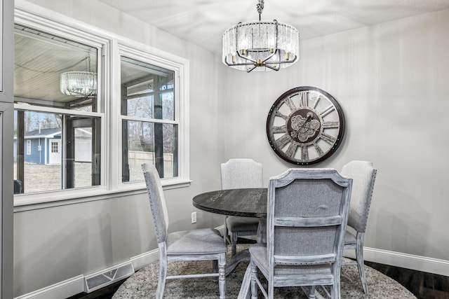 dining area featuring hardwood / wood-style flooring, plenty of natural light, and an inviting chandelier