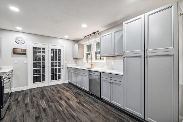 kitchen with appliances with stainless steel finishes, dark hardwood / wood-style flooring, gray cabinetry, and sink