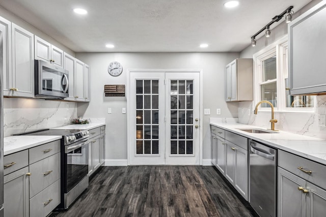 129 Dylark Dr, Waverly, TN 37185 - kitchen featuring appliances with stainless steel finishes, gray cabinetry, decorative backsplash, dark wood finished floors, and recessed lighting