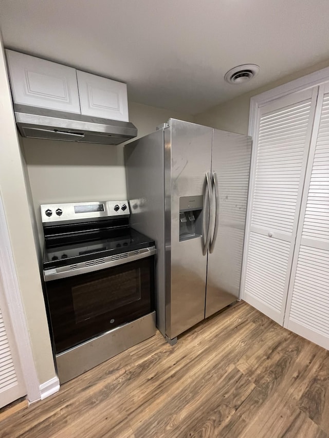 kitchen with white cabinetry, stainless steel appliances, and light wood-type flooring