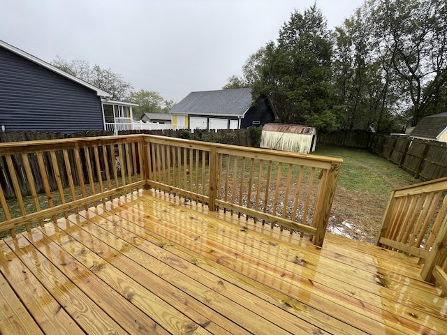 wooden deck featuring a lawn and a shed