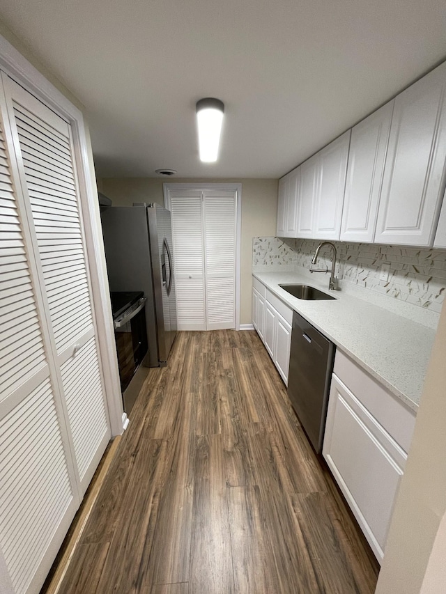 kitchen featuring white cabinets, appliances with stainless steel finishes, dark hardwood / wood-style flooring, and sink