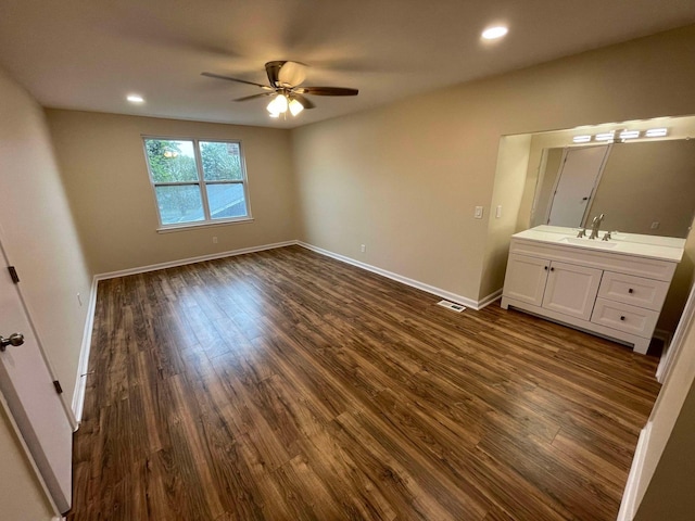 unfurnished bedroom with ceiling fan, sink, and dark hardwood / wood-style floors