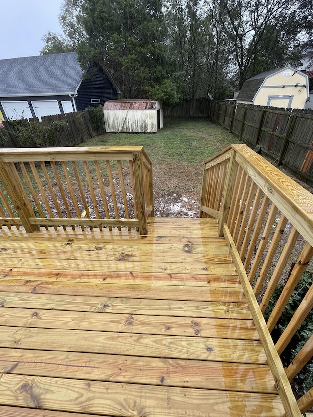 deck featuring a shed and a yard